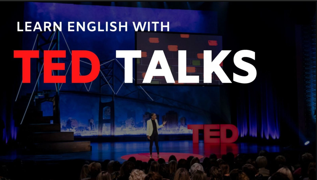 Màn hình laptop đang phát một bài nói chuyện TED Talks, bên cạnh là một cuốn sổ tay đang ghi chép ý chính.